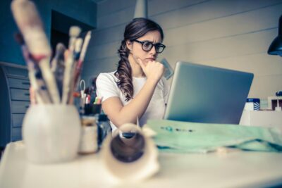 cô gái đang tập trung nhìn vào màn hình laptop
