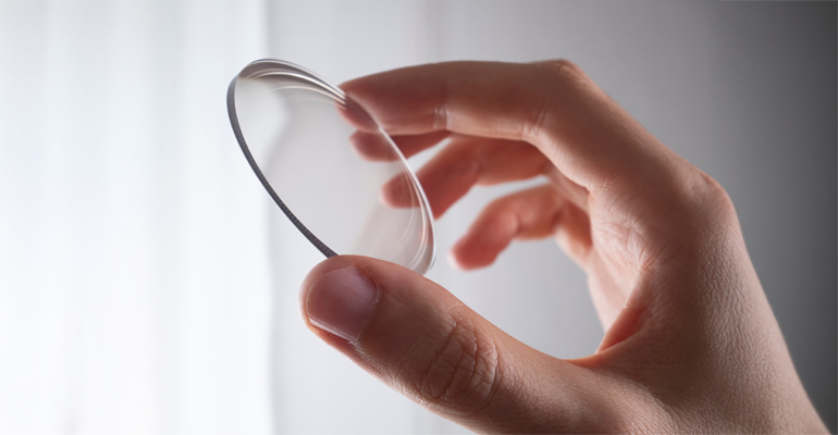 một bàn tay đang cầm tròng kính