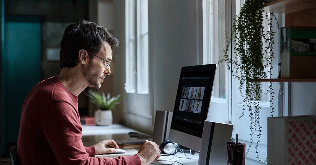 người đàn ông đang đeo tròng kính Rodenstock nhìn vào màn hình máy vi tính