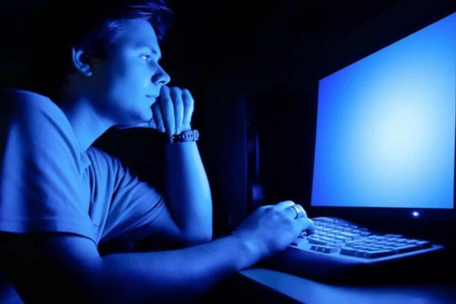 một người đang nhìn vào màn hình chiếu ánh sáng xanh