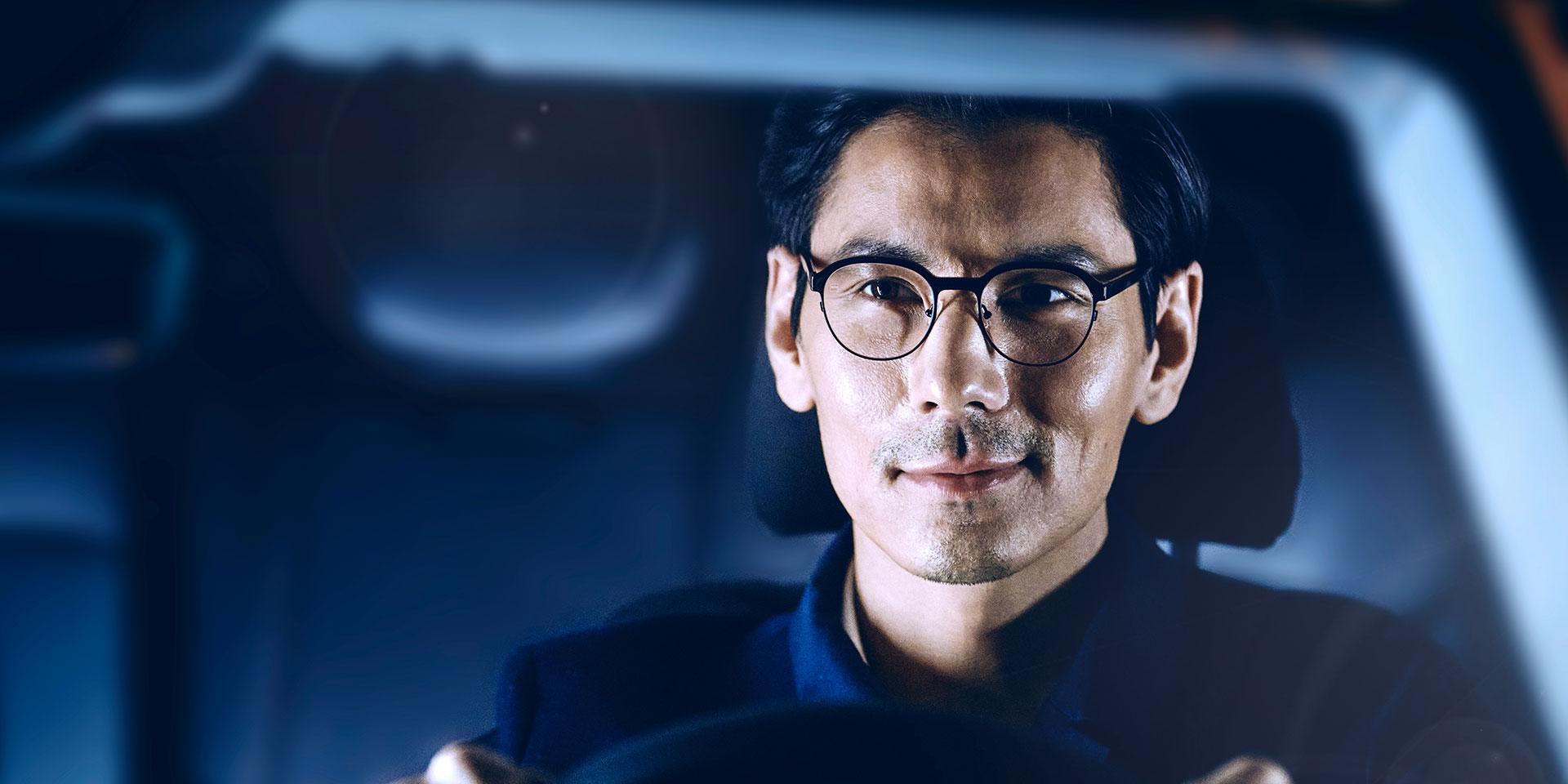 người đàn ông đeo tròng kính Zeiss đang lái xe