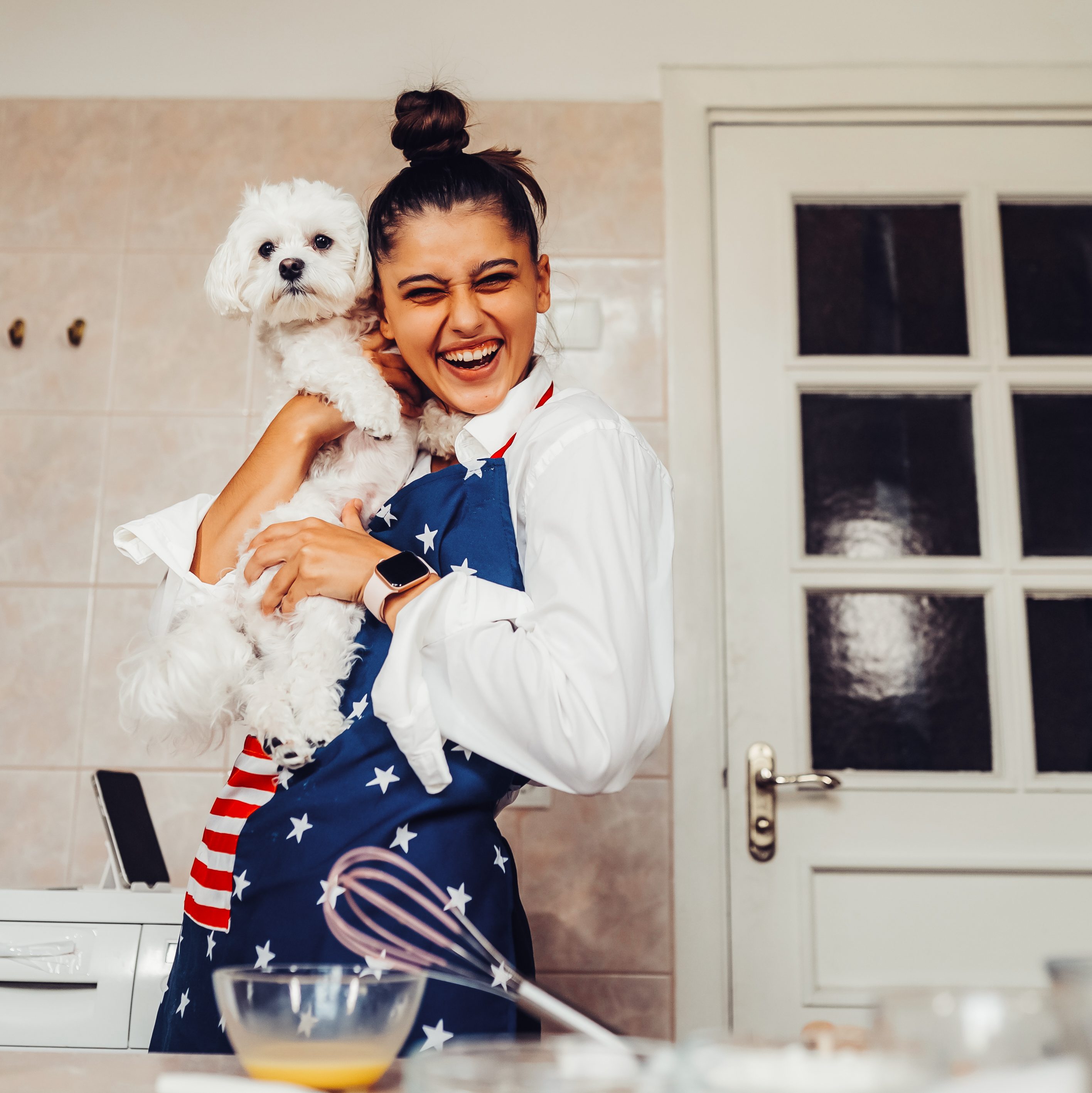 smiling woman kitchen holding cute white maltese dog e1792393471485 58
